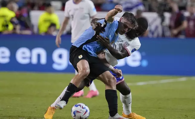 Uruguay's Rodrigo Bentancur, left, and Yunus Musah, right, of the United States, battle for the ball during a Copa America Group C soccer match, Monday, July 1, 2024, in Kansas City, Mo. (AP Photo/Ed Zurga)