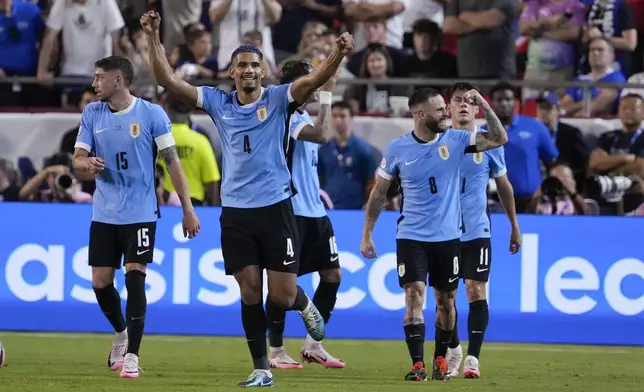 Uruguay's Ronald Araujo (4) celebrates after a goal by Mathias Olivera during a Copa America Group C soccer match against the United States, Monday, July 1, 2024, in Kansas City, Mo. (AP Photo/Ed Zurga)