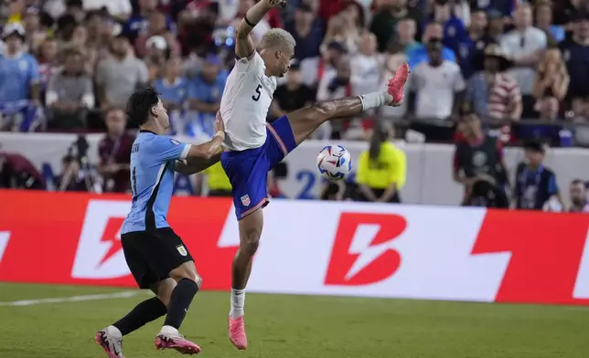 Antonee Robinson, right, of the United States, is defended by Uruguay's Facundo Pellistri, left, during a Copa America Group C soccer match, Monday, July 1, 2024, in Kansas City, Mo. (AP Photo/Ed Zurga)