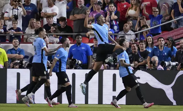 Uruguay's Ronald Araujo, second from right, leaps as he celebrates after a goal by Mathias Olivera, right, during a Copa America Group C soccer match against the United States, Monday, July 1, 2024, in Kansas City, Mo. (AP Photo/Ed Zurga)
