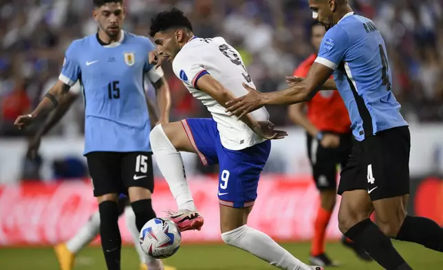 Ricardo Pepi of the United States controls the ball challenged by Uruguay's Ronald Araujo, right, during a Copa America Group C soccer match in Kansas City, Mo., Monday, July 1, 2024. (AP Photo/Reed Hoffman)