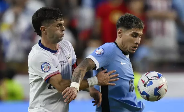 Uruguay's Mathias Olivera, right, controls the ball challenged by Christian Pulisic of the United States during a Copa America Group C soccer match in Kansas City, Mo., Monday, July 1, 2024. (AP Photo/Reed Hoffman)
