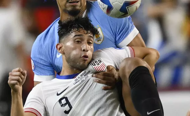 Ricardo Pepi of the United States, front, and Uruguay's Ronald Araujo battle for the ball during a Copa America Group C soccer match in Kansas City, Mo., Monday, July 1, 2024. (AP Photo/Reed Hoffman)