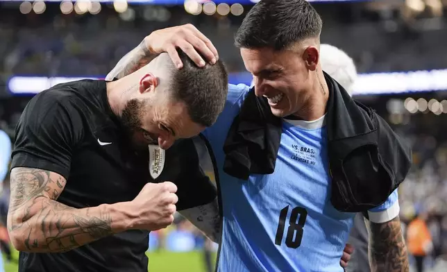 Uruguay's Nahitan Nandez, left, celebrates with teammate Brian Rodriguez defeating Brazil in a penalty shootout during a Copa America quarterfinal soccer match in Las Vegas, Saturday, July 6, 2024. (AP Photo/Julio Cortez)