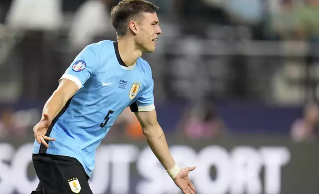 Uruguay's Manuel Ugarte celebrates scoring the winning goal in a penalty shootout against Brazil in a Copa America quarterfinal soccer match in Las Vegas, Saturday, July 6, 2024. (AP Photo/Julio Cortez)