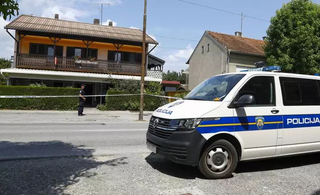 A police officer stands outside the cafe where the shooter was arrested, in Daruvar, central Croatia, Monday, July 22, 2024. An armed assailant entered a care home for older people in central Croatia Monday and opened fire, killing five people and wounding several others, authorities and media reports said. (Zeljko Puhovski/Cropix via AP)