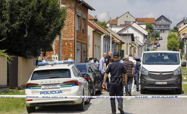 Police and forensics gather near the crime scene in Daruvar, central Croatia, Monday, July 22, 2024. An armed assailant entered a care home for older people in central Croatia Monday and opened fire, killing five people and wounding several others, authorities and media reports said. (Zeljko Puhovski/Cropix via AP)