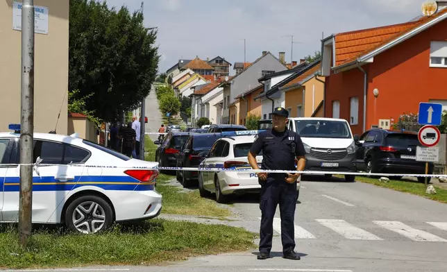 A police officer stands near the crime scene in Daruvar, central Croatia, Monday, July 22, 2024. An armed assailant entered a care home for older people in central Croatia Monday and opened fire, killing five people and wounding several others, authorities and media reports said. (Zeljko Puhovski/Cropix via AP)