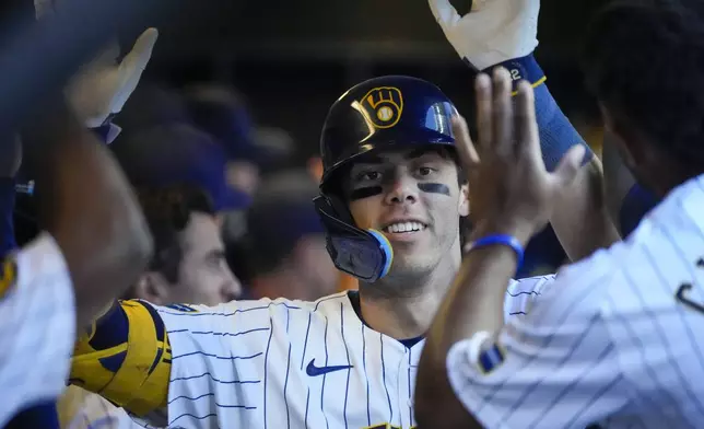 Milwaukee Brewers' Christian Yelich is congratulated after hitting a home run during the fourth inning of a baseball game against the Chicago Cubs Sunday, June 30, 2024, in Milwaukee. (AP Photo/Morry Gash)