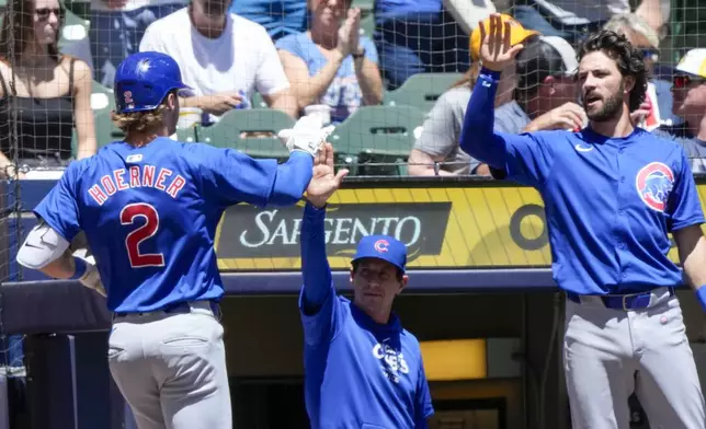 Chicago Cubs' Nico Hoerner is congratulated after hitting a home run during the first inning of a baseball game against the Milwaukee Brewers Sunday, June 30, 2024, in Milwaukee. (AP Photo/Morry Gash)