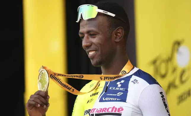 Stage winner Eritrea's Biniam Girmay celebrates on the podium after the third stage of the Tour de France cycling race over 230.8 kilometers (143.4 miles) with start in Piacenza and finish in Turin, Italy, Monday, July 1, 2024. (AP Photo/Daniel Cole)