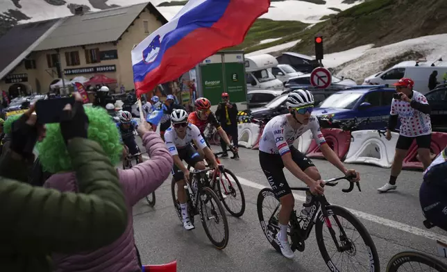 Slovenia's Tadej Pogacar, right, rides to climb the Col du Galibier during the fourth stage of the Tour de France cycling race over 139.6 kilometers (86.7 miles) with start in Pinerolo, Italy and finish in Valloire, France, Tuesday, July 2, 2024. (AP Photo/Daniel Cole)