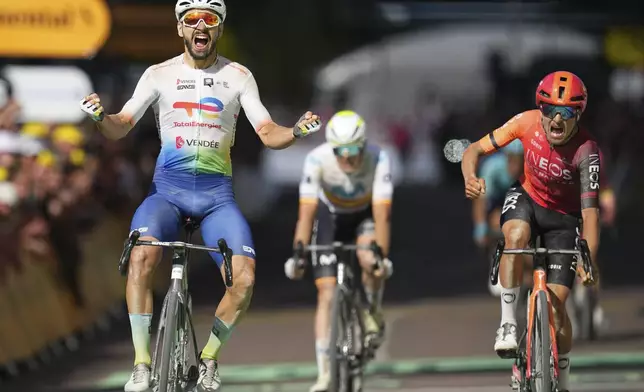 France's Anthony Turgis celebrates as he crosses the finish line to win ahead of Britain's Thomas Pidcock, right, screaming in disappointment, in the ninth stage of the Tour de France cycling race over 199 kilometers (123.7 miles) with start and finish in Troyes, France, Sunday, July 7, 2024. (AP Photo/Daniel Cole)