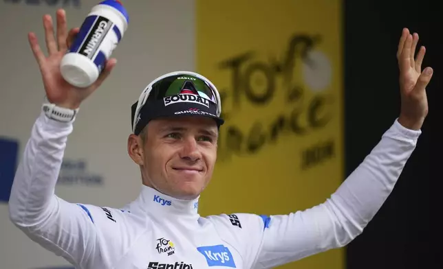 Belgium's Remco Evenepoel, wearing the best young rider's white jersey, celebrates on the podium after the nineteenth stage of the Tour de France cycling race over 144.6 kilometers (89.9 miles) with start in Embrun and finish in Isola 2000, France, Friday, July 19, 2024. (AP Photo/Daniel Cole)