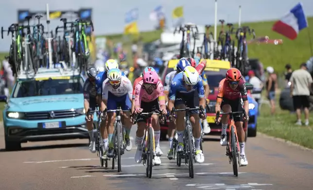 France's Anthony Turgis, left, in white, Ireland's Ben Healy, center left in pink, Spain's Oier Lazkano. Center right in blue, and Britain's Thomas Pidcock, right in red, ride breakaway during the ninth stage of the Tour de France cycling race over 199 kilometers (123.7 miles) with start and finish in Troyes, France, Sunday, July 7, 2024. (AP Photo/Jerome Delay)