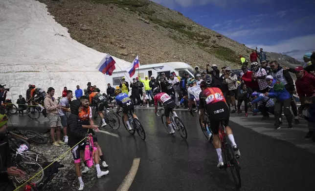Riders ride to climb the Col du Galibier during the fourth stage of the Tour de France cycling race over 139.6 kilometers (86.7 miles) with start in Pinerolo, Italy and finish in Valloire, France, Tuesday, July 2, 2024. (AP Photo/Daniel Cole)
