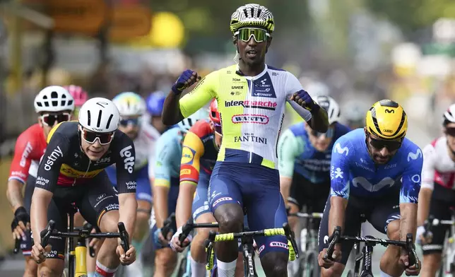 Eritrea's Biniam Girmay celebrates winning ahead of Belgium's Arnaud de Lie, left, and Colombia's Fernado Gavira, right, during the third stage of the Tour de France cycling race over 230.8 kilometers (143.4 miles) with start in Piacenza and finish in Turin, Italy, Monday, July 1, 2024. (AP Photo/Daniel Cole)