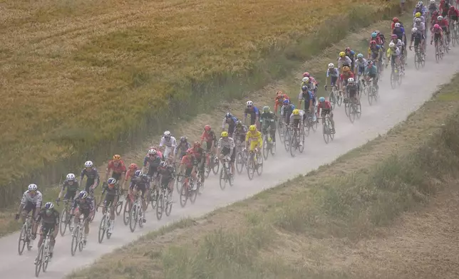 The pack rides on a gravel road during the ninth stage of the Tour de France cycling race over 199 kilometers (123.7 miles) with start and finish in Troyes, France, Sunday, July 7, 2024. (AP Photo/Daniel Cole)