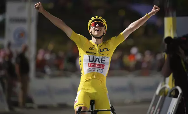 Stage winner Slovenia's Tadej Pogacar, wearing the overall leader's yellow jersey, celebrates as he crosses the finish line of the fifteenth stage of the Tour de France cycling race over 198 kilometers (123 miles) with start in Loudenvielle and finish on Plateau de Beille, France, Sunday, July 14, 2024. (AP Photo/Daniel Cole)