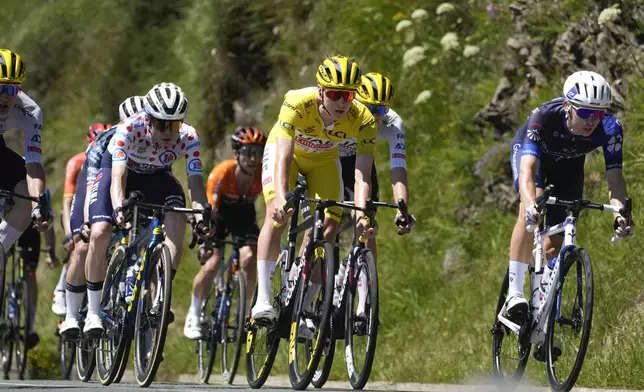 Slovenia's Tadej Pogacar, wearing the overall leader's yellow jersey, Denmark's Jonas Vingegaard, wearing the best climber's dotted jersey as the runner-up, and France's Romain Gregoire, right, speed down Peyresourde pass during the fifteenth stage of the Tour de France cycling race over 198 kilometers (123 miles) with start in Loudenvielle and finish on Plateau de Beille, France, , Sunday, July 14, 2024. (AP Photo/Jerome Delay)