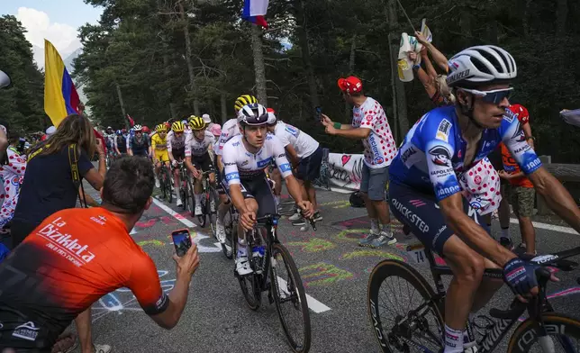 Belgium's Remco Evenepoel, wearing the best young rider's white jersey, center, follows teammate Spain's Mikel Landa during the twentieth stage of the Tour de France cycling race over 132.8 kilometers (82.5 miles) with start in Nice and finish in La Couillole pass, France, Saturday, July 20, 2024. (AP Photo/Daniel Cole)