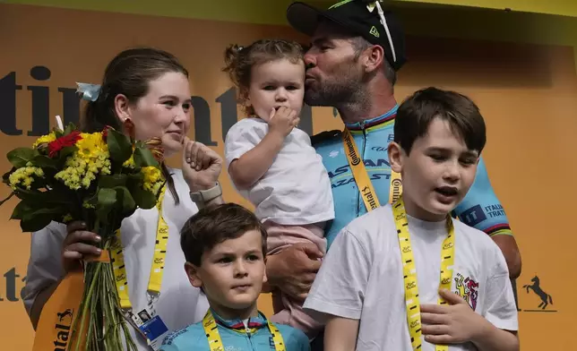 Britain's sprinter Mark Cavendish celebrates on the podium with his wife and children after winning a record 35th Tour de France stage to break the record of Belgian legend Eddy Merckx in the fifth stage of the Tour de France cycling race over 177.4 kilometers (110.2 miles) with start in Saint-Jean-de-Maurienne and finish in Saint-Vulbas, France, Wednesday, July 3, 2024. (AP Photo/Jerome Delay)