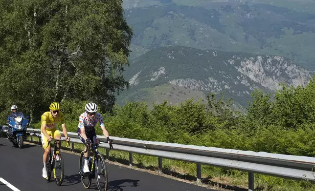 Denmark's Jonas Vingegaard, wearing the best climber's dotted jersey as the runner-up, leads before stage winner Slovenia's Tadej Pogacar, wearing the overall leader's yellow jersey, as they climb towards Plateau de Beille during the fifteenth stage of the Tour de France cycling race over 198 kilometers (123 miles) with start in Loudenvielle and finish on Plateau de Beille, France, Sunday, July 14, 2024. (AP Photo/Jerome Delay)