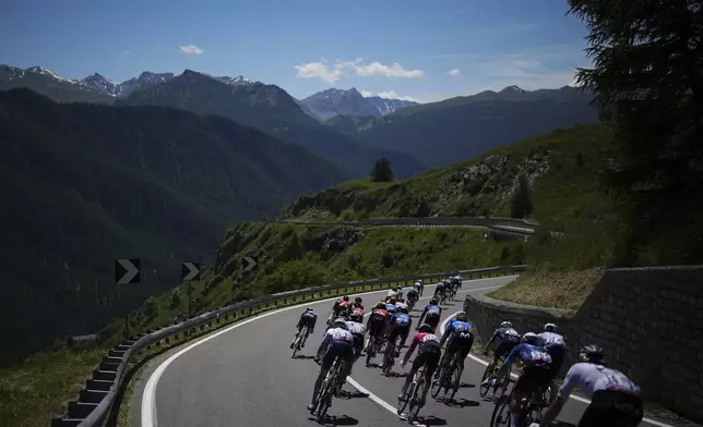 The pack rides during the fourth stage of the Tour de France cycling race over 139.6 kilometers (86.7 miles) with start in Pinerolo, Italy and finish in Valloire, France, Tuesday, July 2, 2024. (AP Photo/Daniel Cole)