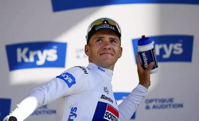 Belgium's Remco Evenepoel, wearing the best young rider's white jersey, throws his drinking bottle to fans from the podium of the eighteenth stage of the Tour de France cycling race over 179.5 kilometers (111.5 miles) with start in Gap and finish in Barcelonette, France, Thursday, July 18, 2024. (AP Photo/Jerome Delay)