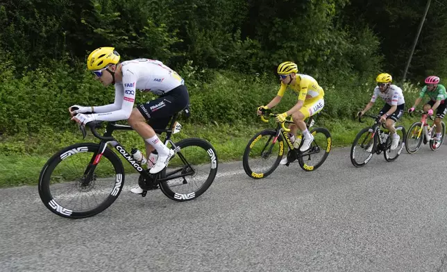 Slovenia's Tadej Pogacar, wearing the overall leader's yellow jersey, follows teammate France's Pavel Sivakov, with teammate Britain's Adam Yates in third position and Italy's Alberto Bettiol in fourth position during the fifth stage of the Tour de France cycling race over 177.4 kilometers (110.2 miles) with start in Saint-Jean-de-Maurienne and finish in Saint-Vulbas, France, Wednesday, July 3, 2024. (AP Photo/Jerome Delay)