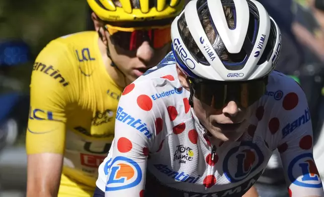 Denmark's Jonas Vingegaard, wearing the best climber's dotted jersey as the runner-up, leads before stage winner Slovenia's Tadej Pogacar, wearing the overall leader's yellow jersey, as they climb towards Plateau de Beille during the fifteenth stage of the Tour de France cycling race over 198 kilometers (123 miles) with start in Loudenvielle and finish on Plateau de Beille, France, Sunday, July 14, 2024. (AP Photo/Jerome Delay)