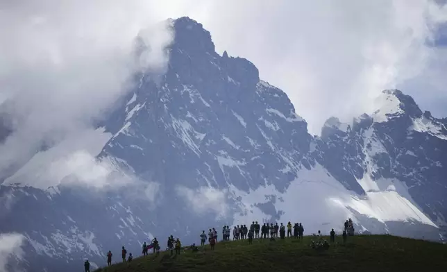 Spectators wait the riders to pass in the Col du Galibier during the fourth stage of the Tour de France cycling race over 139.6 kilometers (86.7 miles) with start in Pinerolo, Italy and finish in Valloire, France, Tuesday, July 2, 2024. (AP Photo/Daniel Cole)