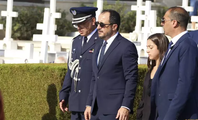 Cyprus President, second left, Nicos Christodoulides attends the memorial service for the soldiers, killed during the 1974 Turkish invasion of Cyprus, in the Tymvos Macedonitissas military cemetery during the 50th anniversary in the divided capital of Nicosia, Cyprus, Saturday, July 20, 2024. Saturday marks the 50th anniversary of Cyprus' ethnic division after Turkish invaded in the summer of 1974 in the wake of an Athens junta-backed coup aiming at union with Greece. (AP Photo/Philippos Christou)