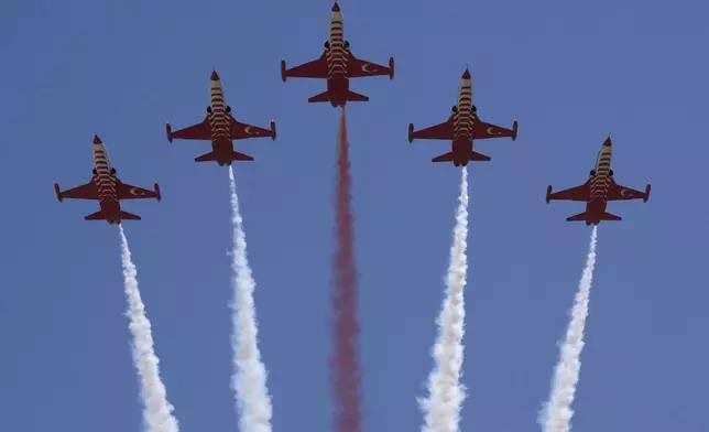 Turkey's acrobatic aircrafts fly over the military parade, in the Turkish occupied area of the divided capital Nicosia, Cyprus, Saturday, July 20, 2024. (AP Photo/Petros Karadjias)