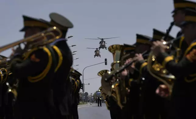 Turkish military helicopters fly over the military parade, in the Turkish occupied area of the divided capital Nicosia, Cyprus, Saturday, July 20, 2024. (AP Photo/Petros Karadjias)