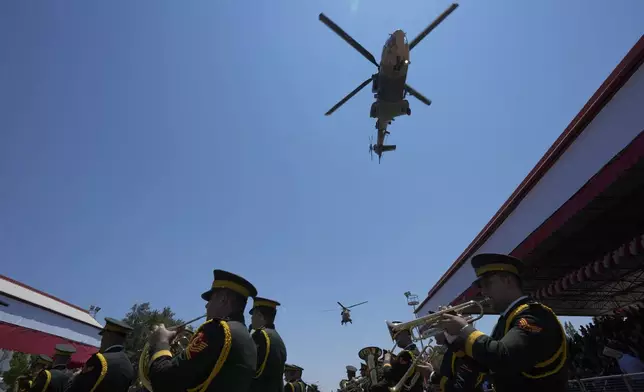 Turkish military helicopters fly over the military parade, in the Turkish occupied area of the divided capital Nicosia, Cyprus, Saturday, July 20, 2024. (AP Photo/Petros Karadjias)