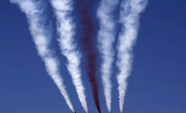 Turkey's acrobatic aircrafts fly over the military parade, in the Turkish occupied area of the divided capital Nicosia, Cyprus, Saturday, July 20, 2024. (AP Photo/Petros Karadjias)