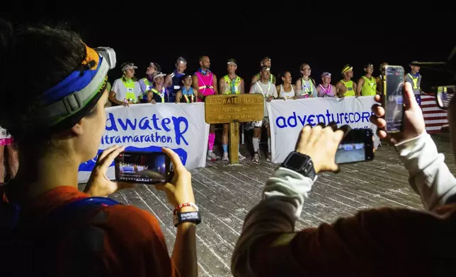 Runners line up for a photo at Badwater Basin, the lowest elevation point in North America, during the Badwater 135 mile (217 kilometer) ultramarathon in Death Valley, Calif., Monday, July 22, 2024. (AP Photo/Ty ONeil)