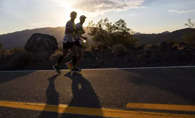 Ivan Penalba Lopez, left, from Spain, and his pacer run as the sun rises during the Badwater 135 mile (217 kilometer) ultramarathon in Death Valley, Calif., Tuesday, July 23, 2024. (AP Photo/Ty ONeil)