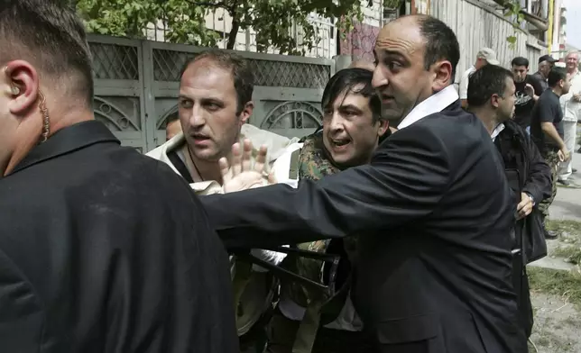 FILE Bodyguards escort Georgian President Mikhail Saakashvili, center, to shelter under a threat of Russian air attack in Gori, Georgia, Monday, Aug. 11, 2008. A pro-Western reformist, Saakashvili was president in 2004-13 and was renowned for his energetic efforts against Georgia's endemic corruption, but Georgians became increasingly uneasy with what they saw as his authoritarian inclinations and his sometimes-mercurial behavior. (AP Photo/Sergei Grits, File)