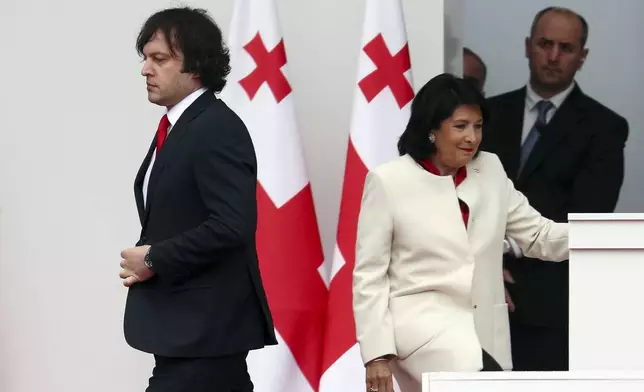 FILE Georgian President Salome Zourabichvili, right, and Prime Minister Irakli Kobakhidze, left, leave a podium after celebration of the Independence Day in Tbilisi, Georgia, on May 26, 2024. Zourabichvili, Georgia's pro-Western president at odds with the ruling party, vetoed the divisive foreign influence bill after it was passed by the parliament. Georgian Dream – the ruling party – had enough votes to override her veto. The bill was signed into law early June. (Irakli Gedenidze/Pool Photo via AP, File)