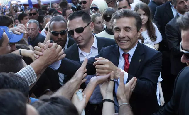 FILE Georgia's billionaire and opposition leader Bidzina Ivanishvili, right, mingles with his supporters during a rally in the center of Georgia's capital Tbilisi, on Sept. 29, 2012. Ivanishvili, a former prime minister, made his fortune in Russia. His Georgian Dream party promised to restore civil rights, "reset" relations with Moscow and pursue membership in the European Union. It has, however, been accused of creeping authoritarianism, especially not pursuing reforms necessary to ensure juridical independence. (AP Photo/Georgy Abdaladze, File)