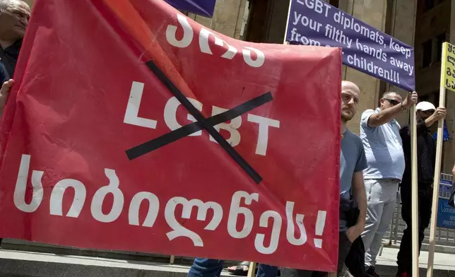 FILE Georgian far right parties and their supporters hold a banner that reads: "No to LGBT darkness", as they gather in front of the Parliament building during a rally against Pride Week in Tbilisi, Georgia, on July 2, 2022. Journalists, campaigners and analysts who spoke to the AP cast it as part of sustained efforts to crack down on critics before a parliamentary election in October, and neuter civil society by advancing repressive "Russia-style" measures - including fresh legislation targeting LGBTQ+ people. They also described an atmosphere of fear and intimidation, with opponents of the bill being harassed, threatened and sometimes physically assaulted. (AP Photo/Shakh Aivazov, File)