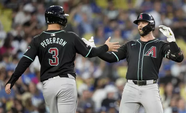 Arizona Diamondbacks' Christian Walker celebrates hitting a two-run home run with designated hitter Joc Pederson, who also scored, during the fourth inning of a baseball game against the Los Angeles Dodgers, Tuesday, July 2, 2024, in Los Angeles. (AP Photo/Ryan Sun)