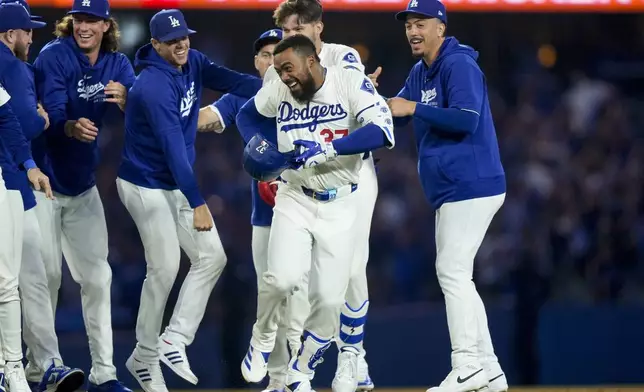 Los Angeles Dodgers' Teoscar Hernandez, center, celebrates with teammates after hitting a walk-off single to score Freddie Freeman during the ninth inning of a baseball game against the Arizona Diamondbacks, Tuesday, July 2, 2024, in Los Angeles. (AP Photo/Ryan Sun)