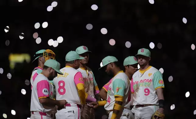 Members of the San Diego Padres wait on the mound during a pitching change in the ninth inning of a baseball game against the Arizona Diamondbacks, Friday, July 5, 2024, in San Diego. (AP Photo/Gregory Bull)