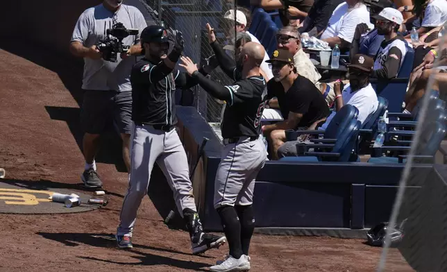 Arizona Diamondbacks' Eugenio Suarez, left, celebrates with teammate Christian Walker after hitting a two-run home run during the seventh inning of a baseball game against the San Diego Padres, Sunday, July 7, 2024, in San Diego. (AP Photo/Gregory Bull)