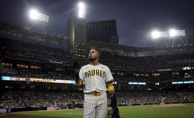 San Diego Padres' Luis Arraez waves to a fan during a pitching change in the fifth inning of a baseball game against the Arizona Diamondbacks, Saturday, July 6, 2024, in San Diego. (AP Photo/Gregory Bull)