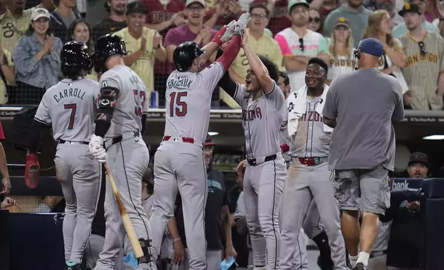 Arizona Diamondbacks' Randal Grichuk, (15) celebrates with teammate Alek Thomas after hitting a two-run home run during the ninth inning of a baseball game against the San Diego Padres, Friday, July 5, 2024, in San Diego. (AP Photo/Gregory Bull)