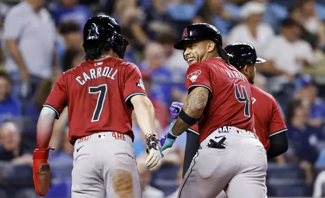 Arizona Diamondbacks' Ketel Marte (4) celebrates hitting a three-run home run with Corbin Carroll (7) during the ninth inning of a baseball game against the Kansas City Royals in Kansas City, Mo., Wednesday, July 24, 2024. (AP Photo/Colin E. Braley)